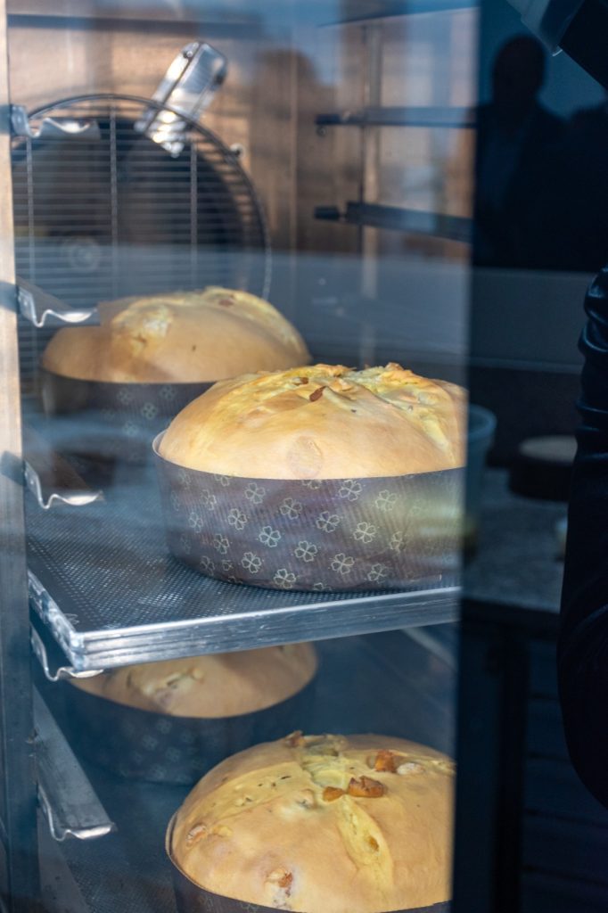 Un panettone in cottura, visto attraverso il vetro del forno