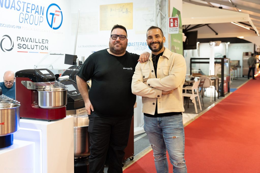 Due professionisti in posa davanti alle impastatrici esposte