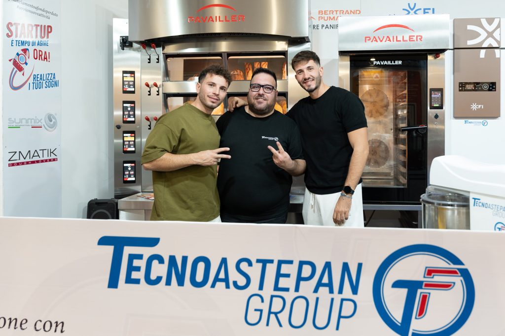 Tre visitatori conversano davanti ai forni Pavailler allo stand